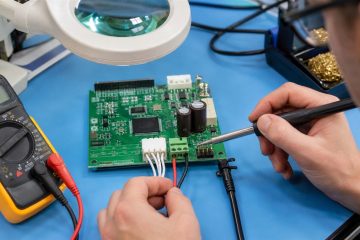Technician checking PCB wire, terminal block and board connector connections with a multimeter
