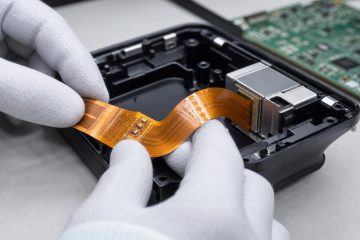 Flexible PCB routed through an electronics enclosure with a reinforced connector end