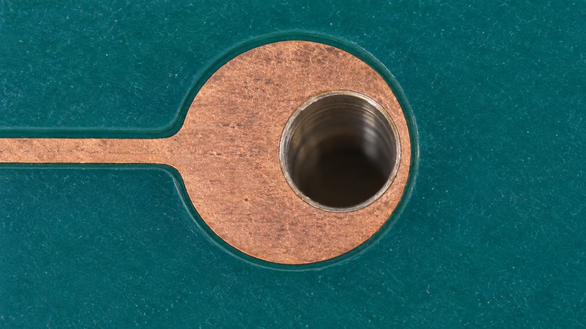 Illustrative off-center hole leaving a narrower copper ring on its right side