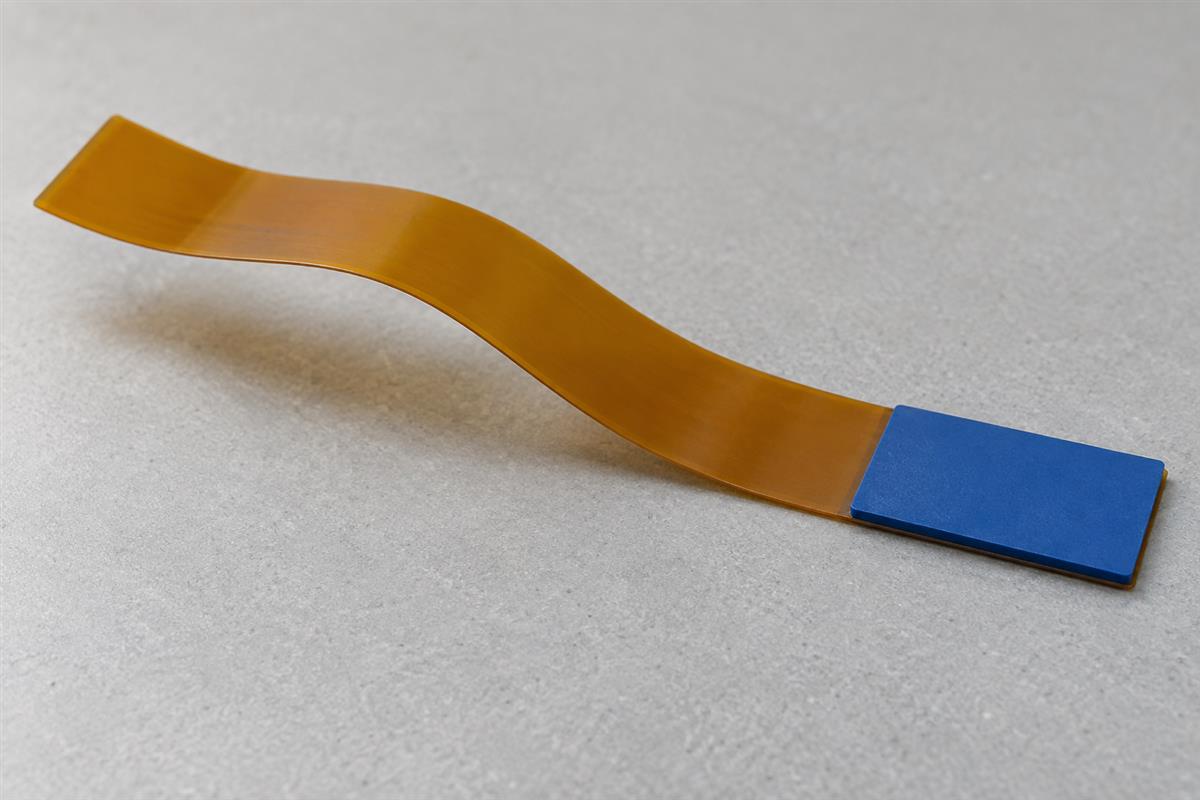 Back view of a flexible circuit tail with local reinforcement, AI illustration