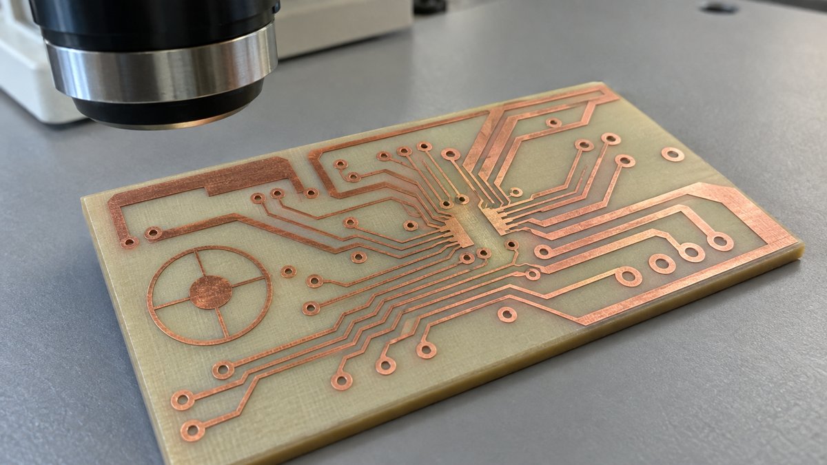 Bare copper circuit pattern and registration target beside an optical inspection lens
