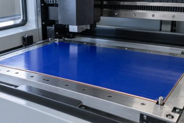 Copper-clad panel covered with blue photoresist on an imaging machine loading bed
