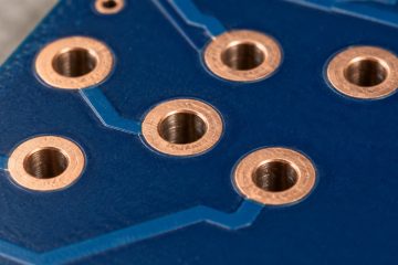 Illustrative PCB showing copper annular rings around plated holes
