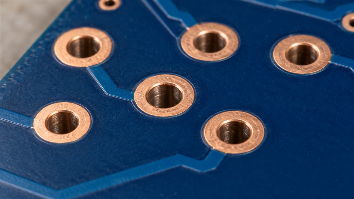 Illustrative PCB showing copper annular rings around plated holes