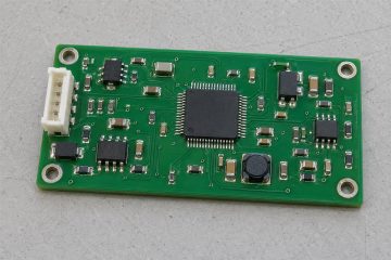 Illustrative assembled green PCB with integrated circuits, small passive components and connector