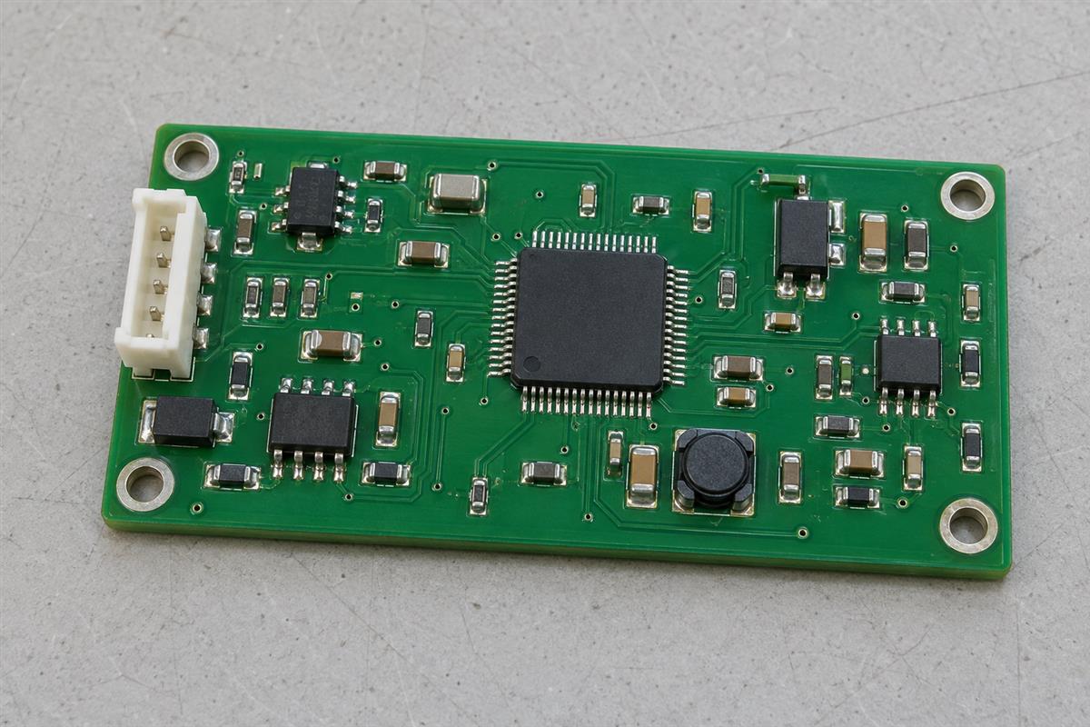 Illustrative assembled green PCB with integrated circuits, small passive components and connector