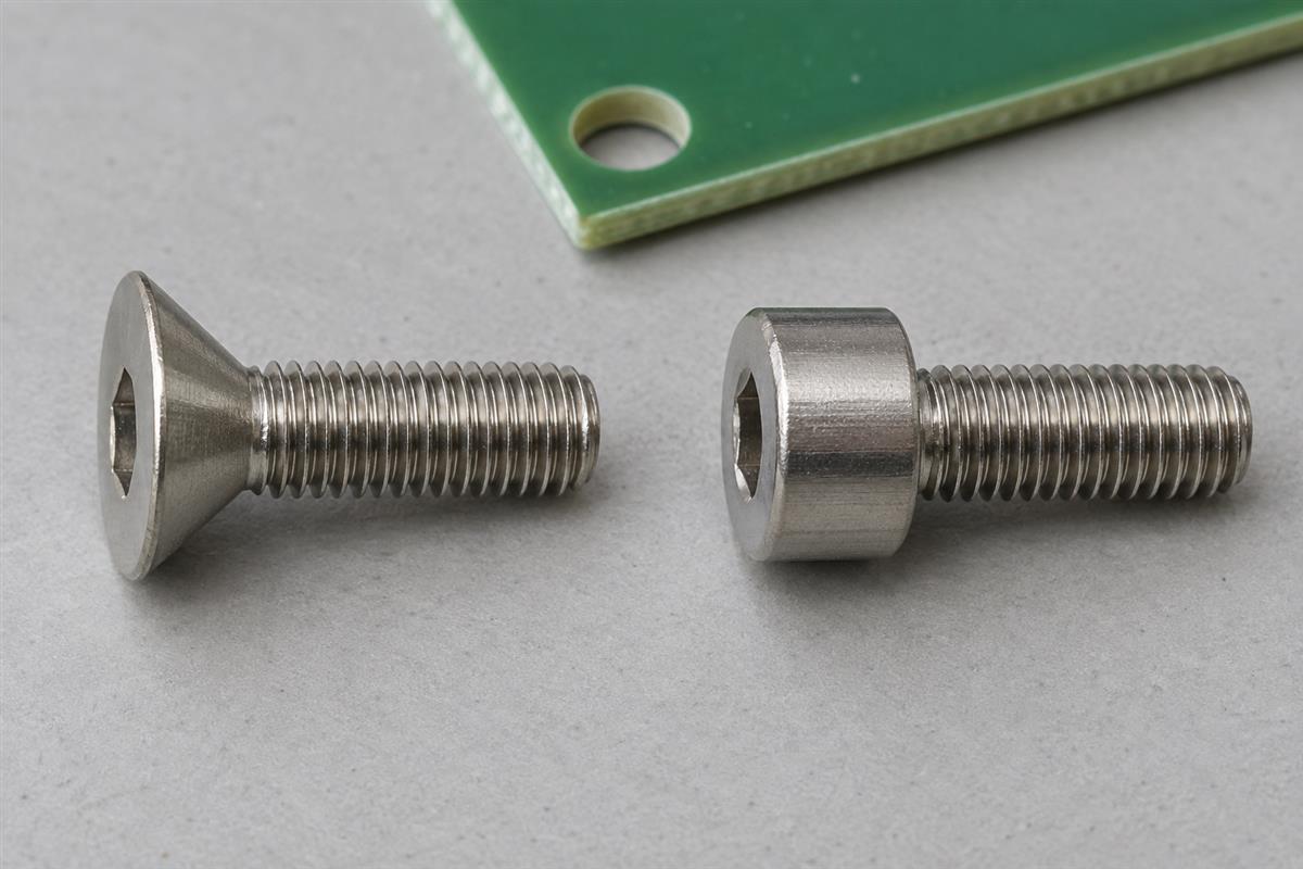 Countersunk and cylindrical socket-head screws beside a circuit board, AI illustration