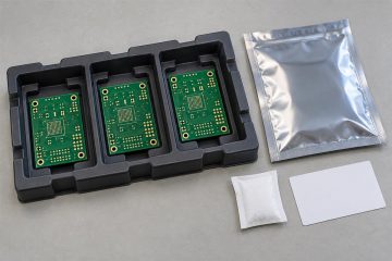 Bare circuit boards separated in a protective shipping tray beside barrier packaging