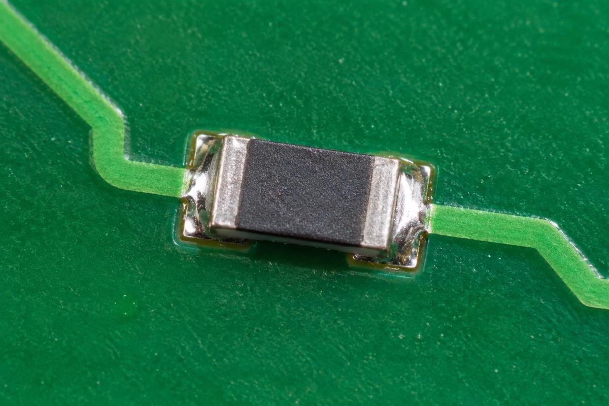 Surface mount resistor soldered to two PCB pads, AI illustration