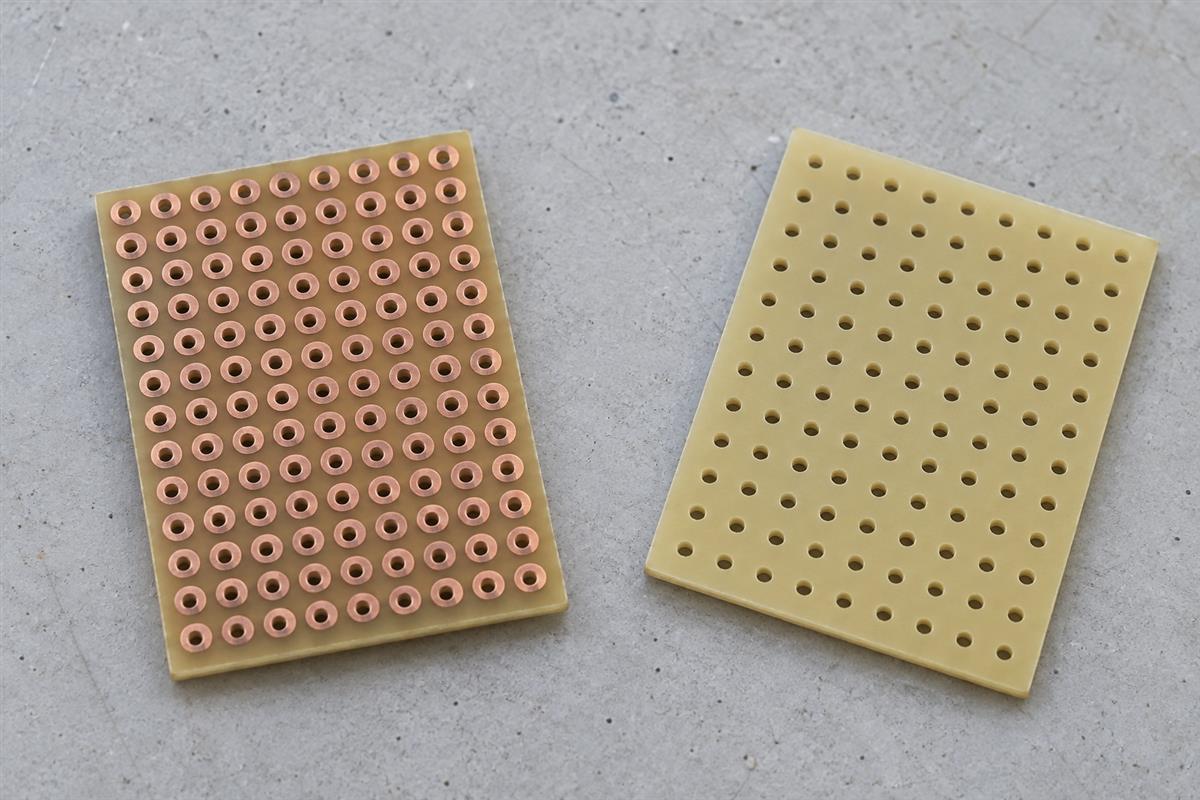 Illustrative isolated-pad perfboard showing copper pads and the component side