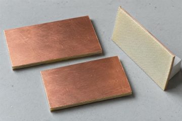 Copper-clad laminate coupons showing copper faces and a bare insulating back, AI illustration