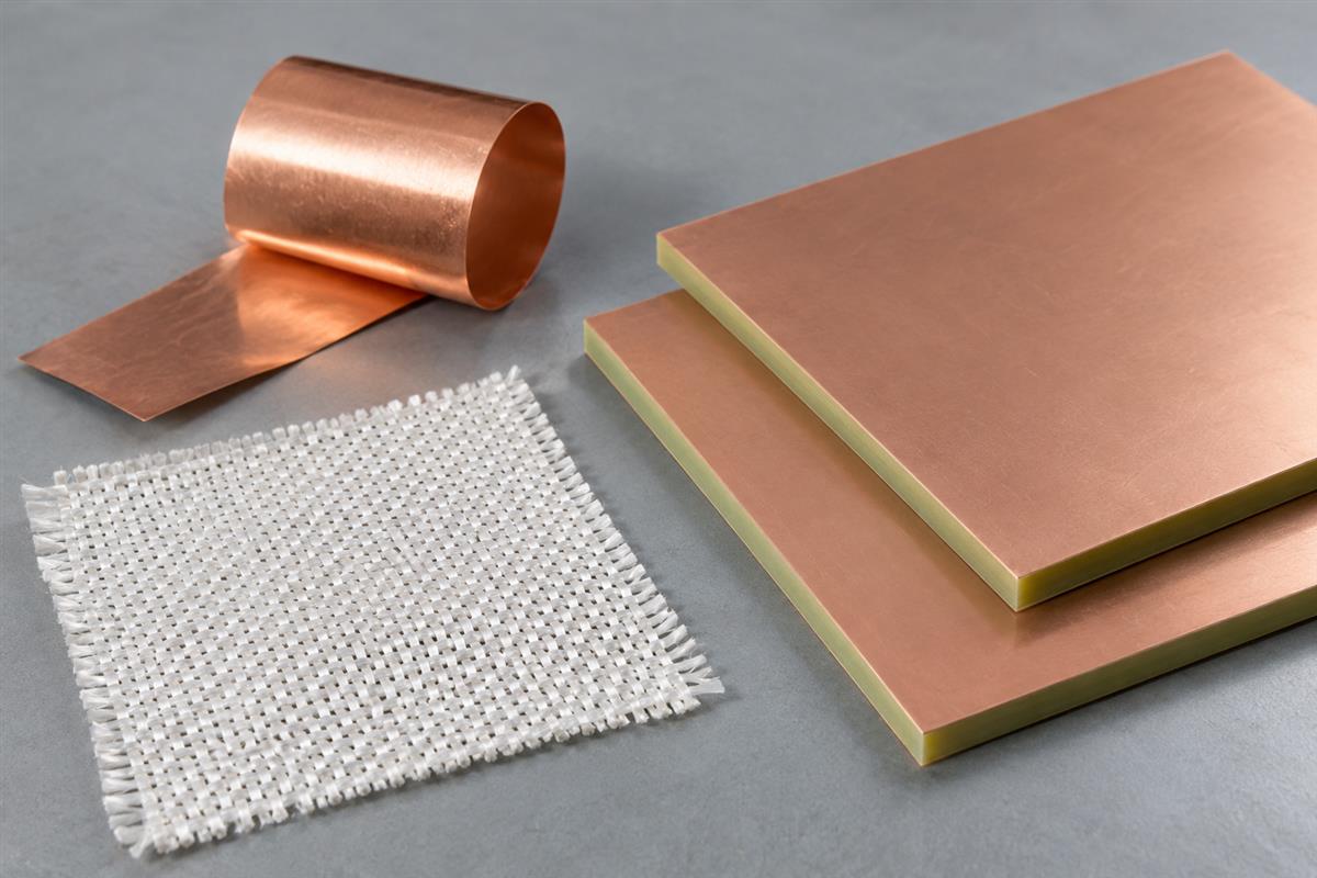 Woven glass reinforcement and copper foil samples beside copper-clad laminate