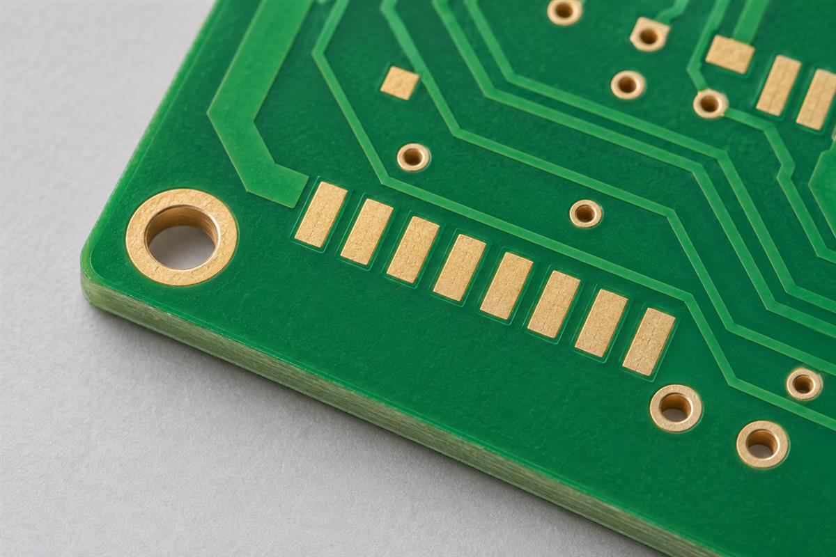 Illustrative close-up of bare PCB solder mask, exposed pads and a routed board edge
